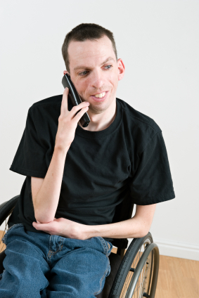 Photo of young man in wheelchair using cellphone